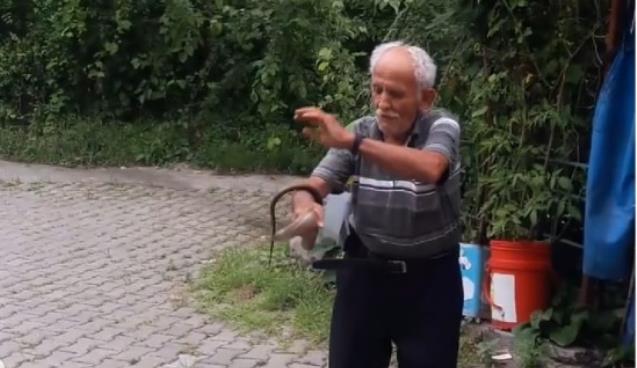 Yılanla kameralara poz verdi.